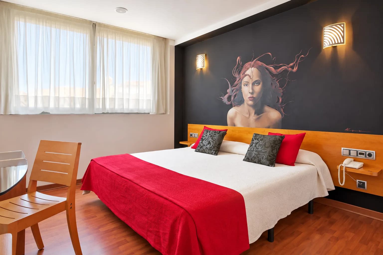 Habitación doble luminosa con mural artístico de mujer sobre la cama en Hotel Plaza Inn, alojamiento en España