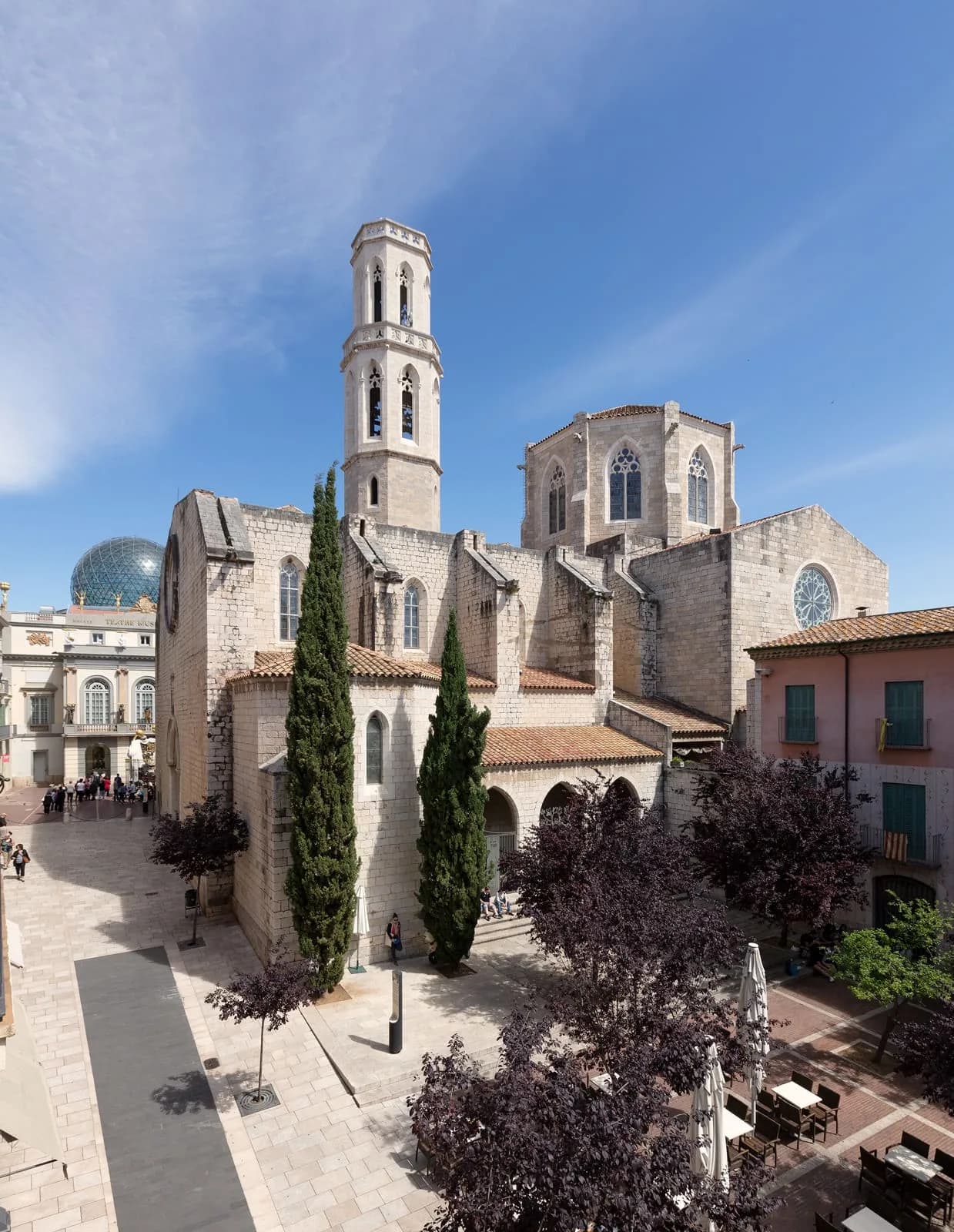 Vista aérea de una iglesia de piedra y plaza peatonal arbolada cerca del Hotel Plaza Inn en un casco histórico de España