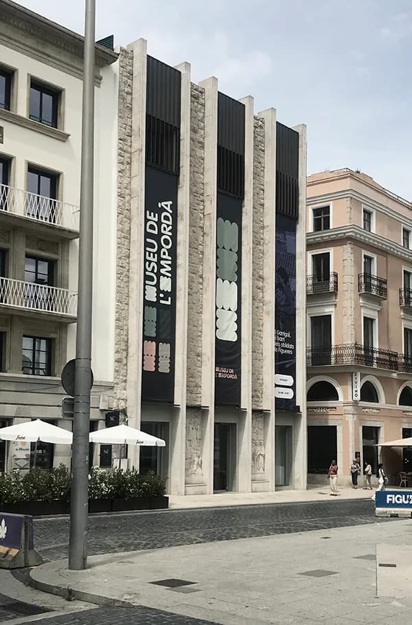 Fachada moderna del Museu de l’Empordà y edificios vecinos en una calle peatonal del centro de Figueres, cerca del Hotel Plaza Inn Spain
